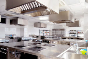 Wide shot of an industrial kitchen, clean and empty.